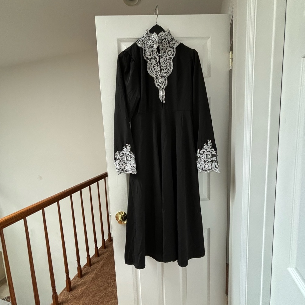 Black, long dress with hand-stitched white lace at collar and cuffs